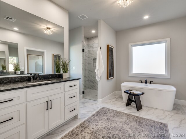 bathroom with plus walk in shower, vanity, and an inviting chandelier