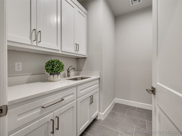 laundry area featuring tile patterned flooring and sink