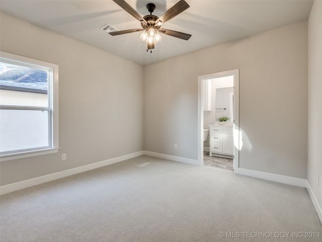 carpeted spare room featuring ceiling fan