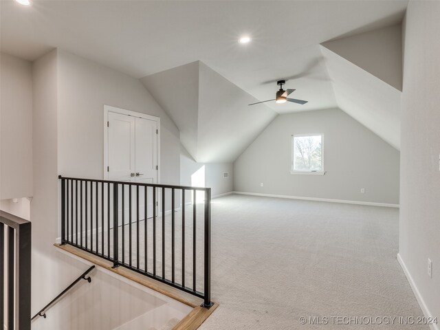 additional living space with carpet flooring, vaulted ceiling, and ceiling fan