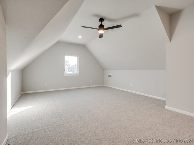 additional living space featuring ceiling fan, light colored carpet, and vaulted ceiling