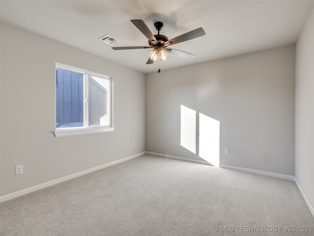 carpeted spare room with ceiling fan