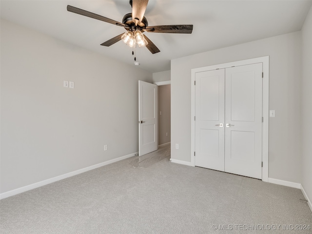 unfurnished bedroom with ceiling fan, a closet, and light carpet