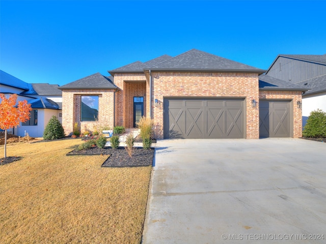 view of front of property featuring a front yard and a garage