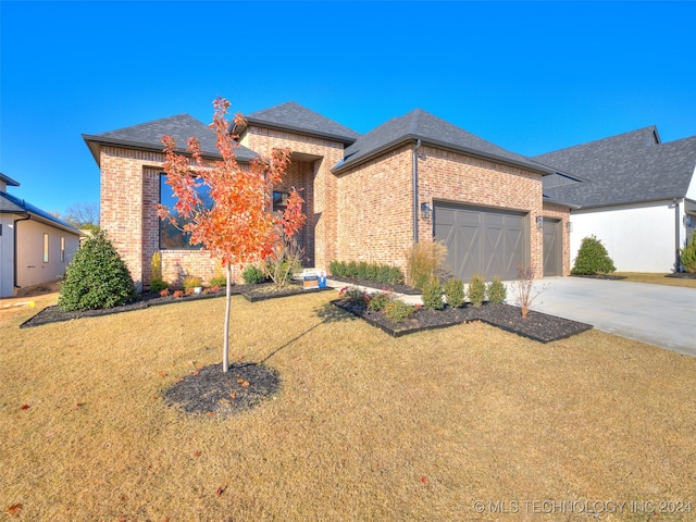 view of front of property with a garage and a front lawn