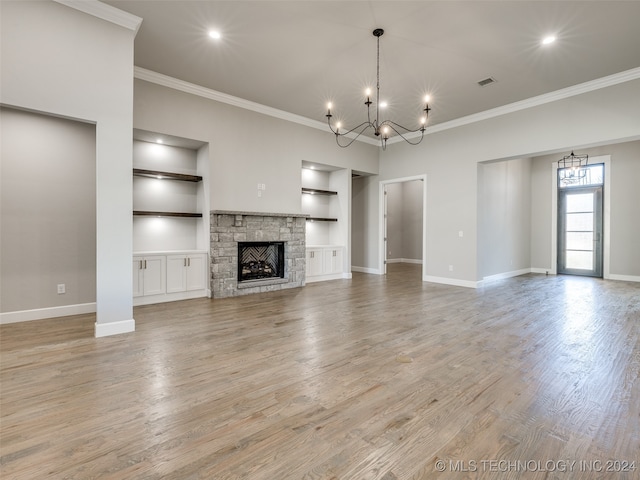 unfurnished living room featuring a fireplace, built in features, light hardwood / wood-style floors, and ornamental molding