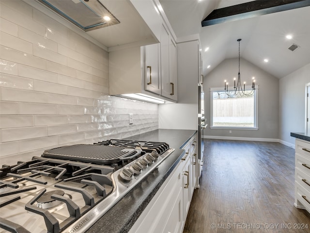 kitchen featuring white cabinetry, stainless steel appliances, dark wood-type flooring, lofted ceiling, and decorative backsplash