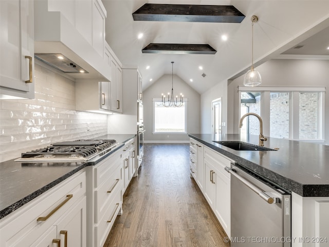 kitchen with custom exhaust hood, a spacious island, sink, decorative light fixtures, and stainless steel appliances