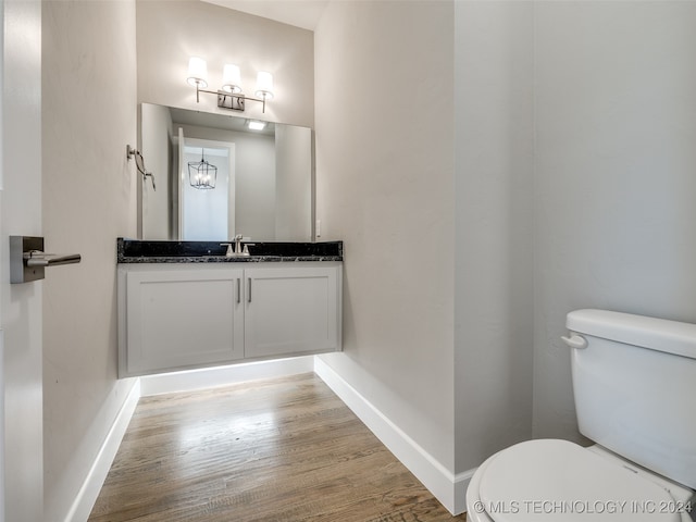 bathroom featuring vanity, hardwood / wood-style flooring, and toilet