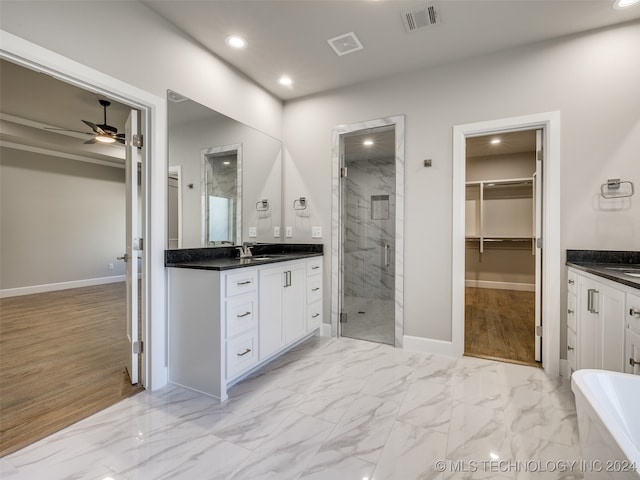 bathroom featuring ceiling fan, vanity, wood-type flooring, and plus walk in shower