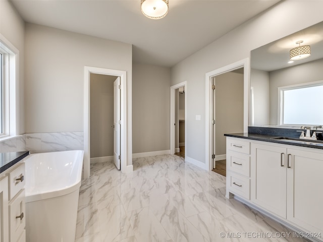 bathroom with a tub to relax in and vanity