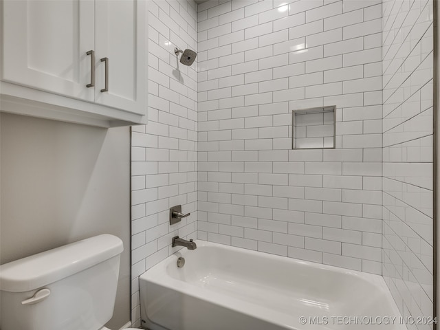 bathroom featuring toilet and tiled shower / bath