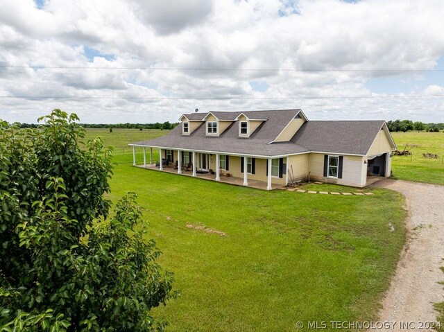 view of front of house with a porch, a rural view, and a front yard