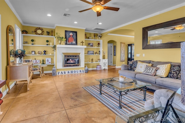 tiled living room with built in features, ceiling fan, and crown molding