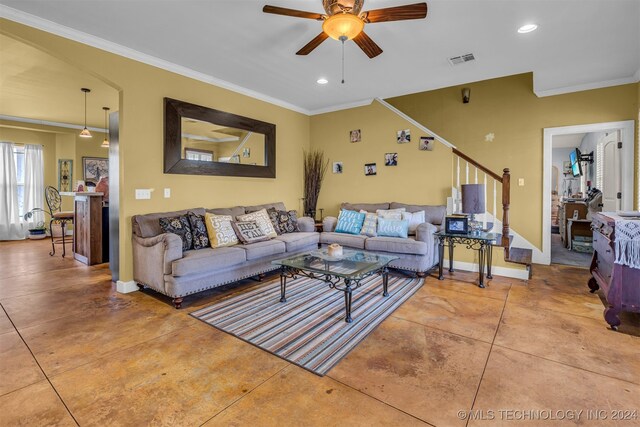 living room with tile patterned floors, crown molding, and ceiling fan