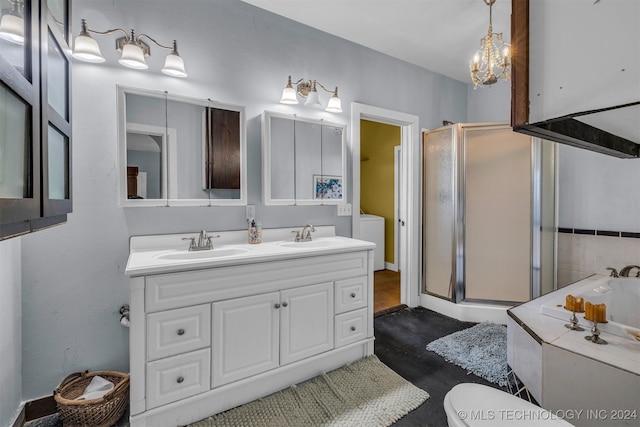 bathroom featuring double vanity, washer / clothes dryer, a shower with door, and toilet