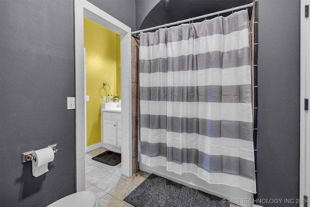 bathroom featuring tile patterned flooring, toilet, and vanity