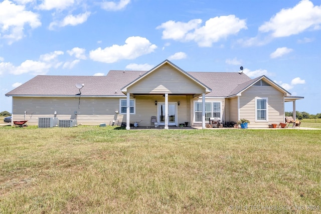 back of property featuring central air condition unit and a lawn