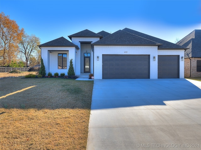 view of front of house with a garage and a front lawn