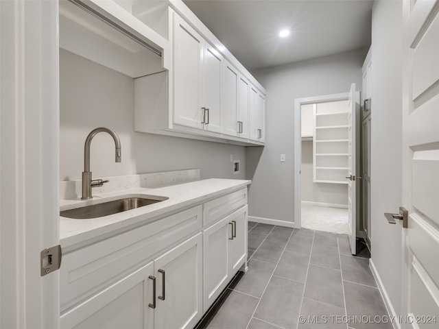 laundry area with washer hookup, cabinets, light tile patterned floors, and sink