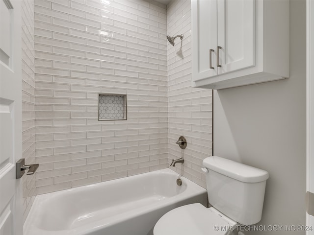 bathroom featuring tiled shower / bath combo and toilet