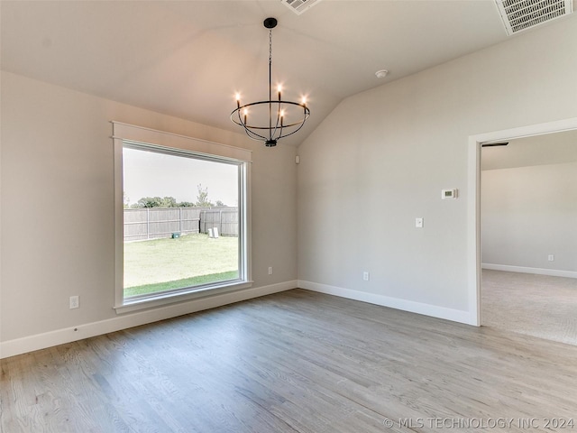 unfurnished room with lofted ceiling, light wood-type flooring, and a chandelier