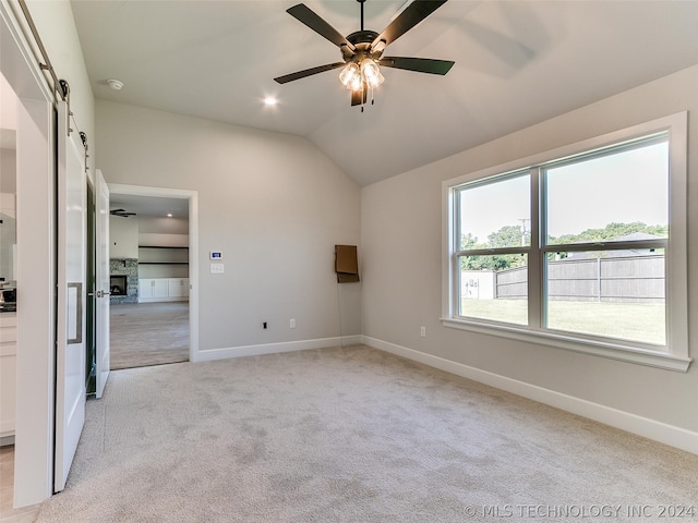 unfurnished bedroom with lofted ceiling, light colored carpet, and ceiling fan