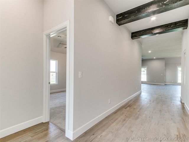 hall featuring beam ceiling and light hardwood / wood-style floors