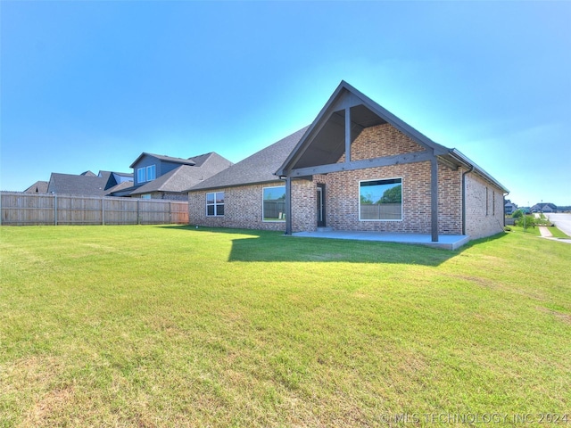 back of property with a yard and a patio area