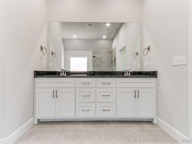 bathroom featuring vanity, tile patterned floors, and walk in shower