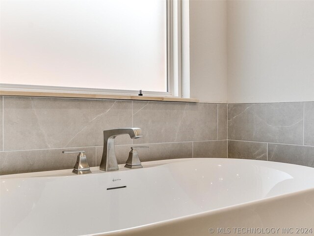 bathroom with sink, tile walls, and a tub