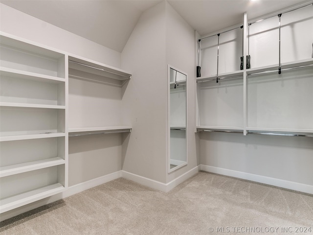 walk in closet featuring light carpet and vaulted ceiling