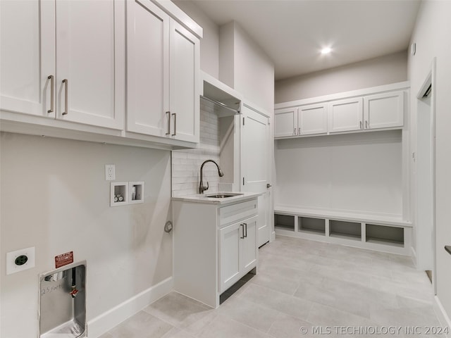 clothes washing area with electric dryer hookup, sink, washer hookup, and light tile patterned floors