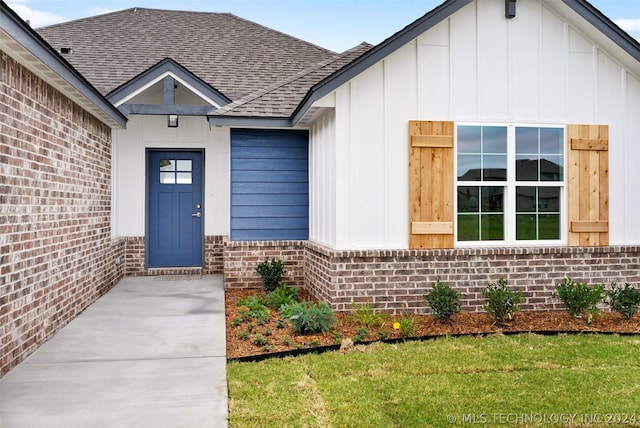 entrance to property with a lawn