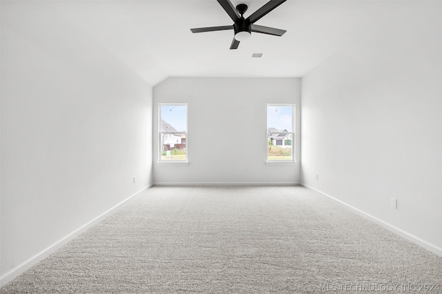 carpeted spare room with ceiling fan and lofted ceiling