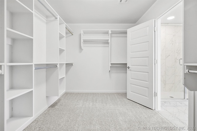 walk in closet featuring light colored carpet