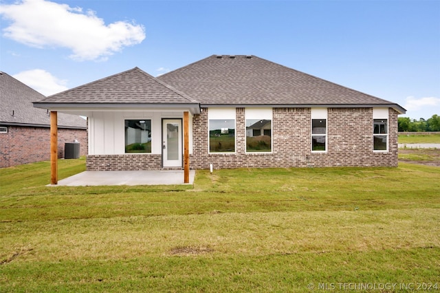 rear view of house featuring a yard, a patio, and central air condition unit