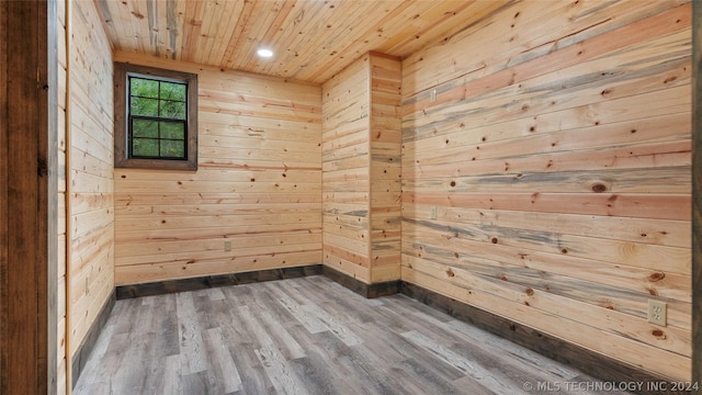 unfurnished room featuring wood ceiling, wood walls, and wood-type flooring