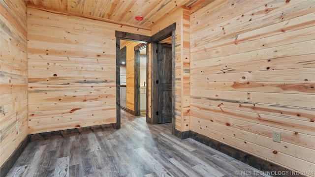 interior space featuring wooden ceiling, dark wood-type flooring, and wood walls