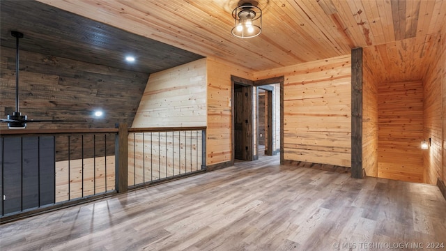 spare room with hardwood / wood-style floors, wood walls, and wooden ceiling