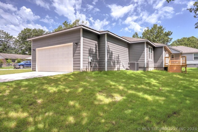 ranch-style home featuring central AC, a front lawn, a garage, and a deck