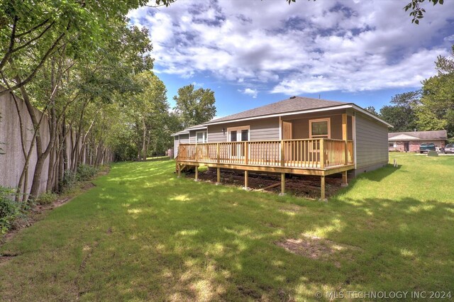 back of property featuring a yard and a deck