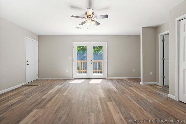 empty room featuring hardwood / wood-style floors, ceiling fan, and french doors