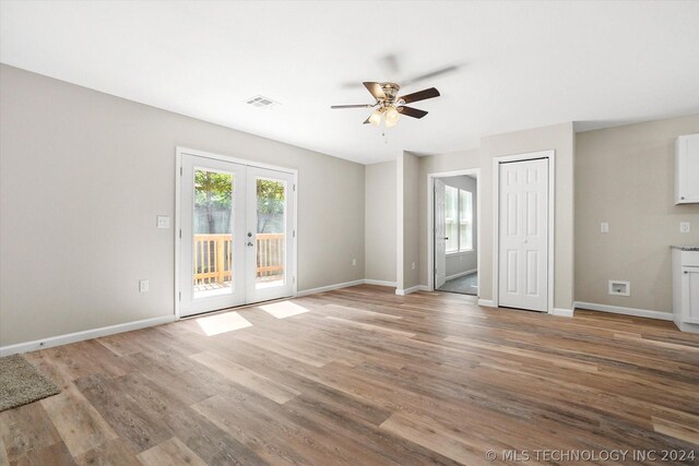 unfurnished living room with hardwood / wood-style flooring, ceiling fan, and french doors