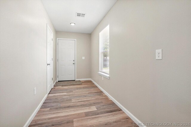 corridor with light hardwood / wood-style flooring