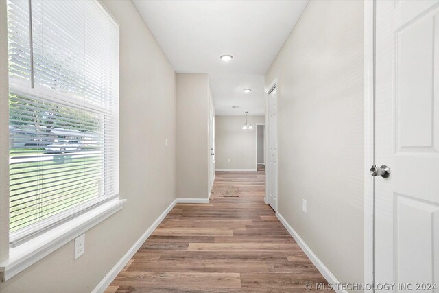 hallway featuring hardwood / wood-style floors and an inviting chandelier