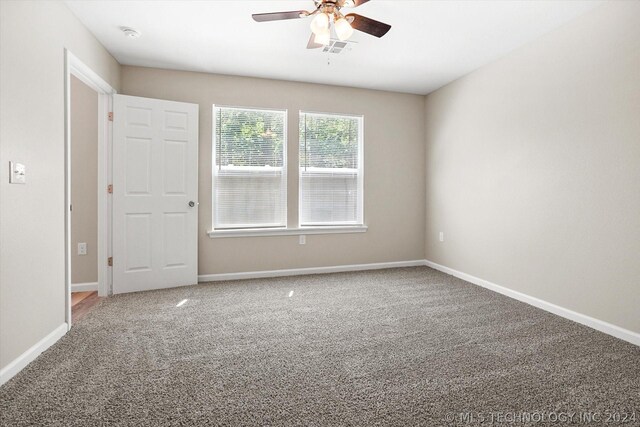 carpeted spare room with ceiling fan