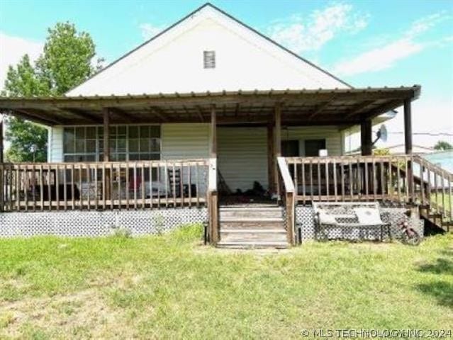 back of house with a yard and a deck