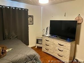 bedroom with dark hardwood / wood-style flooring