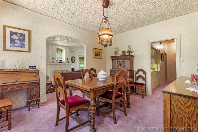 carpeted dining area featuring a chandelier and a textured ceiling